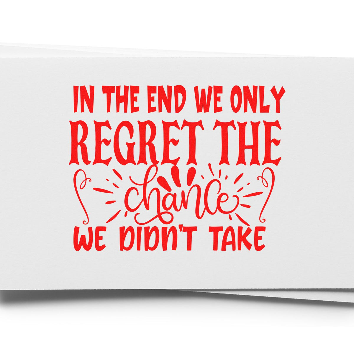 Red decorative rubber stamp design on white paper reading In the end we only regret the chance we didnt take.