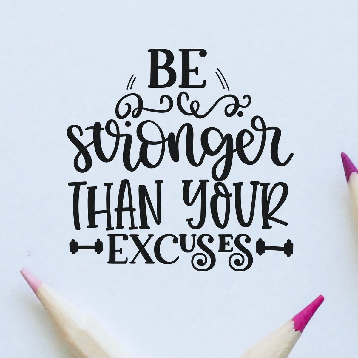 Black motivational stamp and seal design reads Be stronger than your excuses on white, with pink pencil tips.