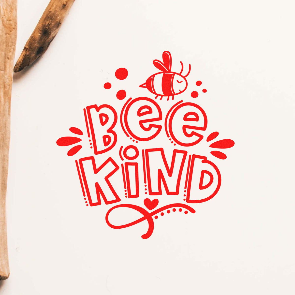 Red Bee Kind stamp seal in bright red with bee graphic on white paper, wooden stamp edges visible.