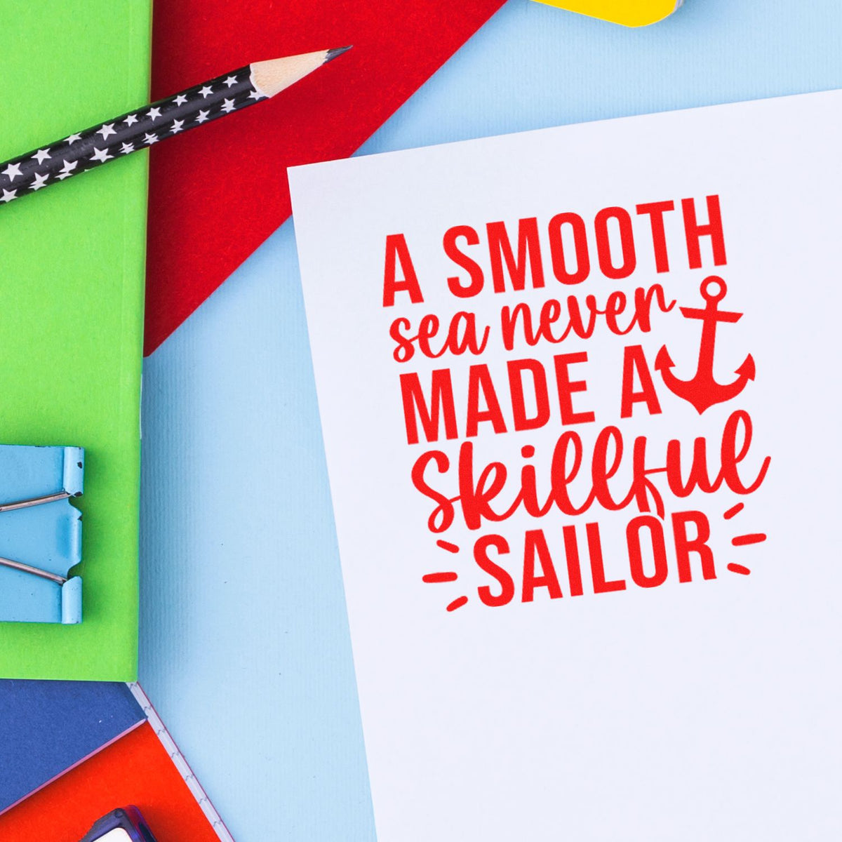 Custom stamp and seal design on white card with red nautical quote, anchor, and colorful green, blue, red, and yellow accents.