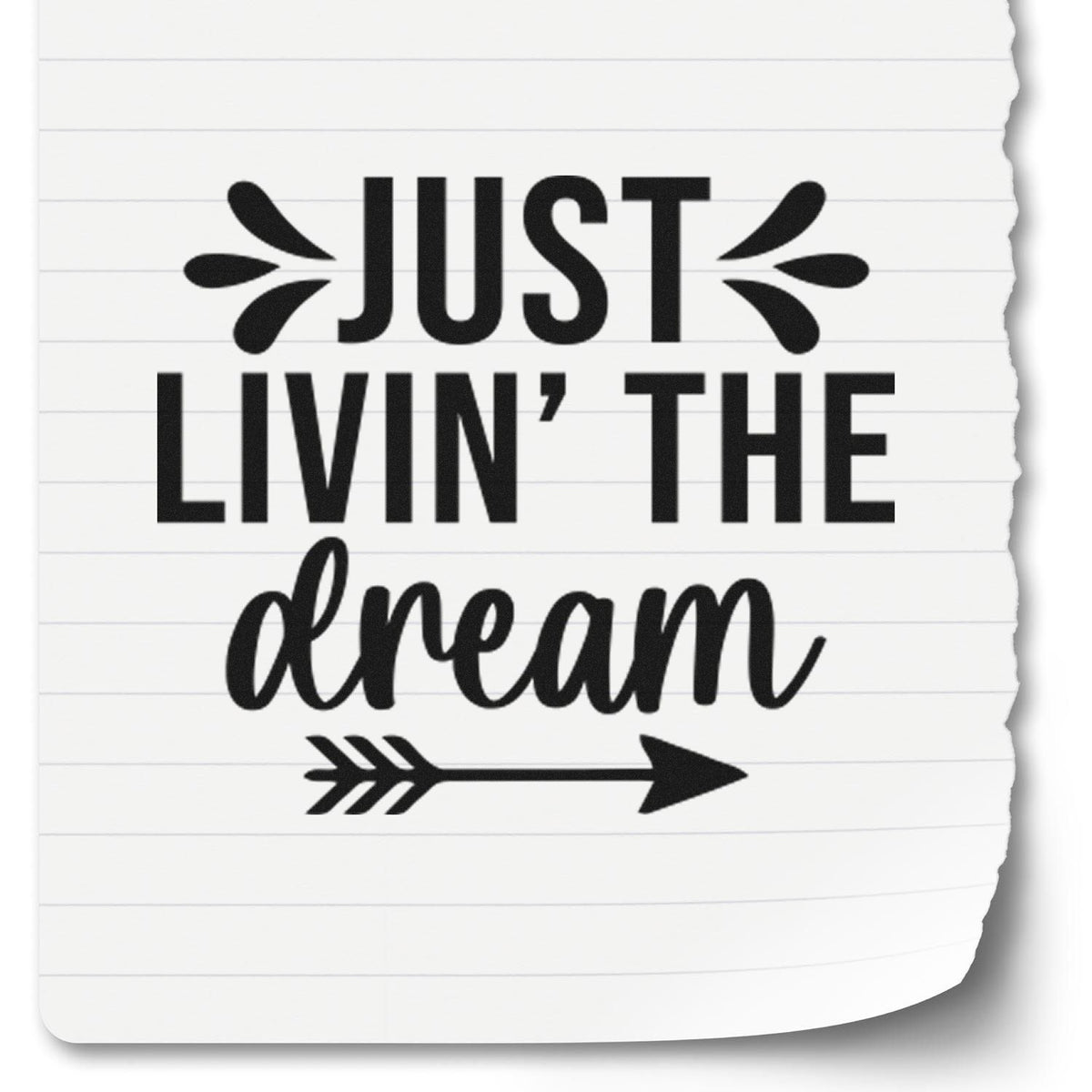 Black rubber stamp design reading Just Livin the Dream with arrow and decorative marks on white lined paper.