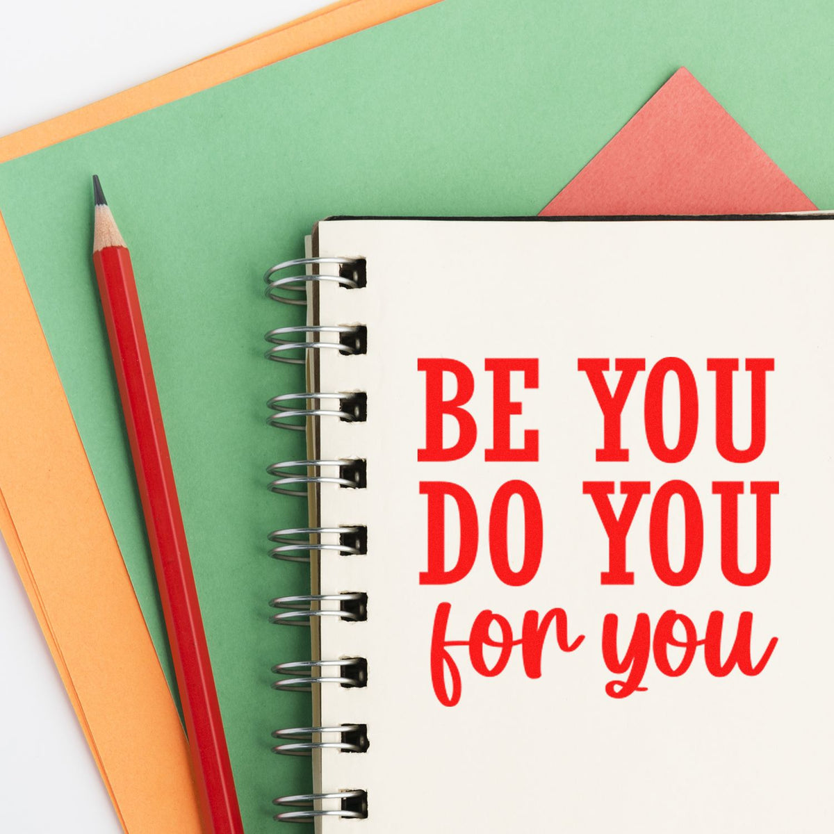 Custom stamp and seal notebook design with red Be you, do you, for you text, red pencil, and green, orange, pink paper.