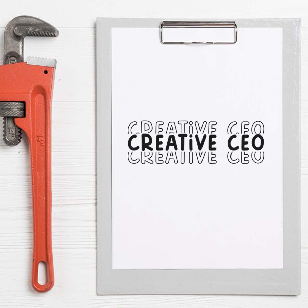 Red-orange custom stamp tool beside a clipboard showing black CREATIVE CEO seal on white paper