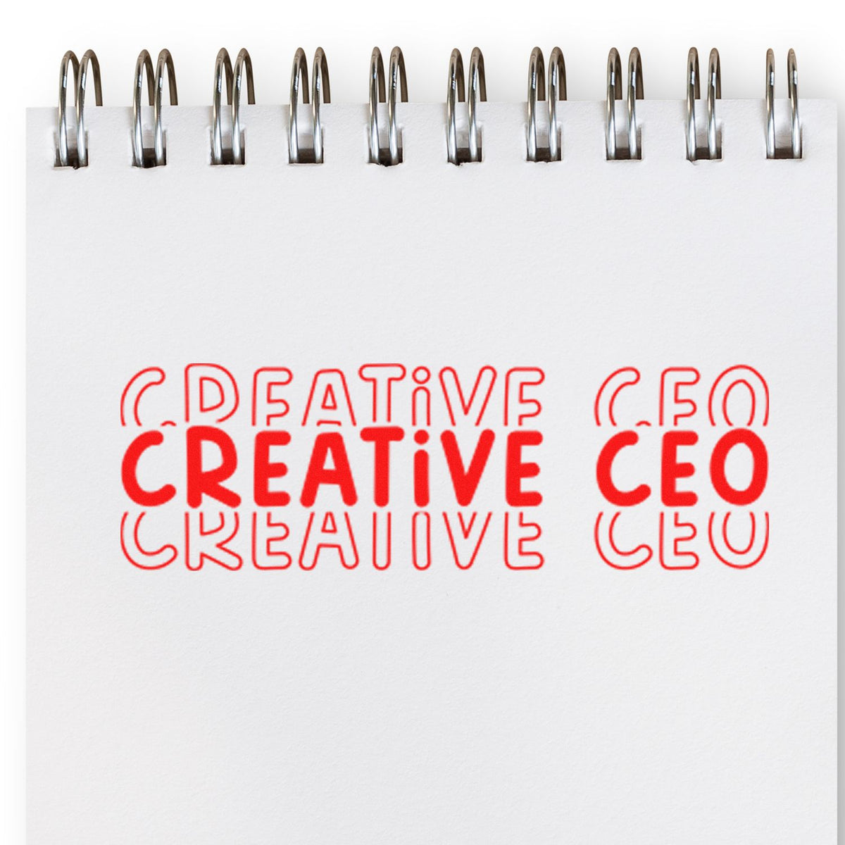Red Creative and CEO stamp and seal impressions on a white spiral-bound notebook page.