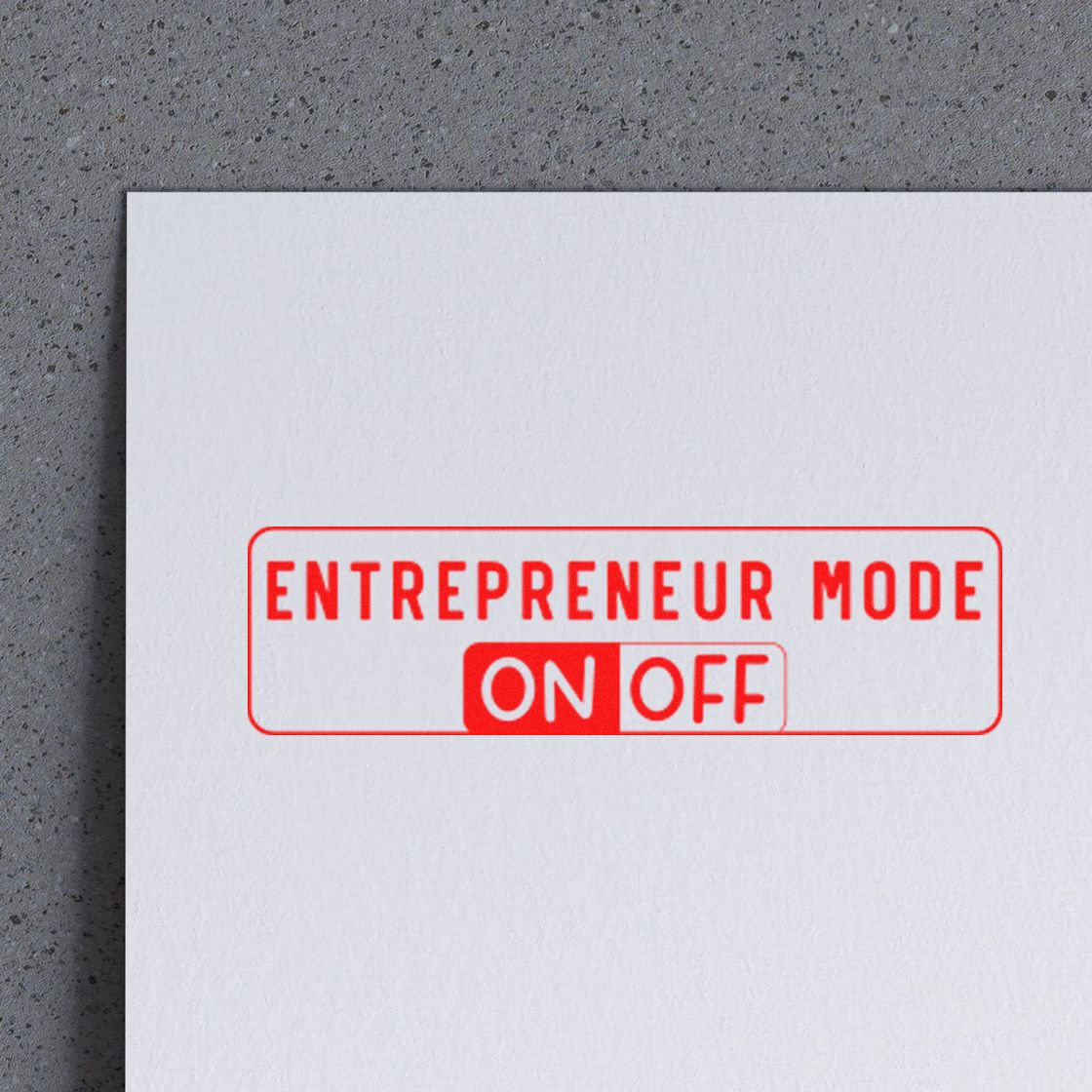 Red entrepreneur mode ON/OFF rubber stamp on white paper against a gray textured background.
