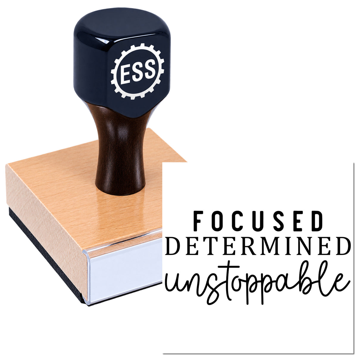 Black ESS rubber stamp and seal on a pink wood block with "Focused Determined unstoppable" slogan.
