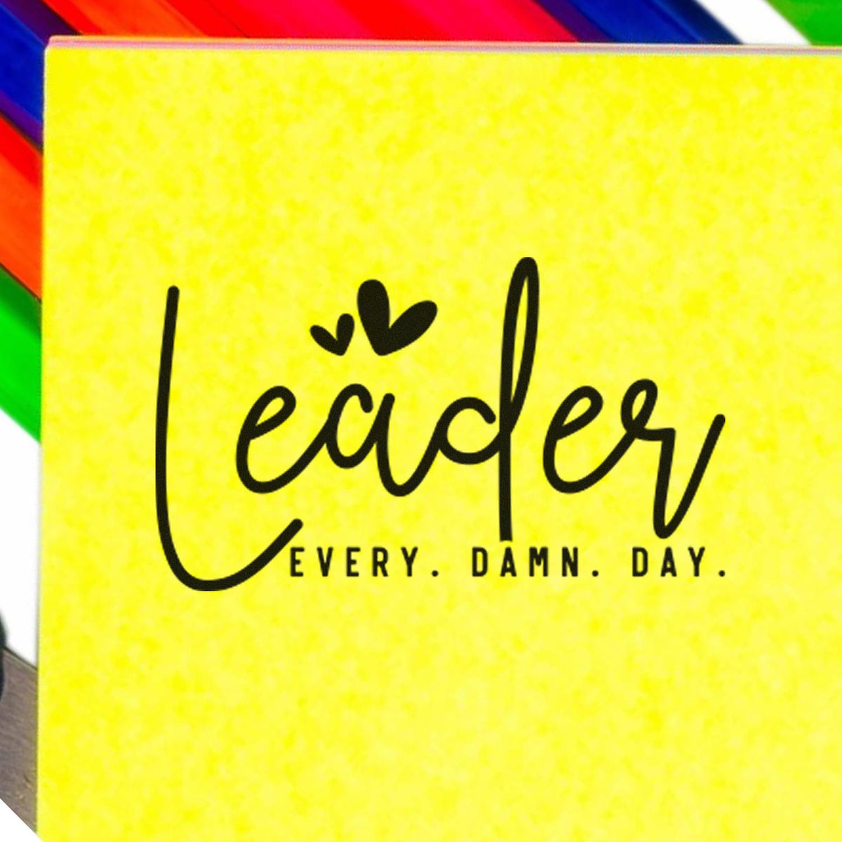 Bright yellow stamp and seal pad with black Leader Every Damn Day script and rainbow-striped edges.