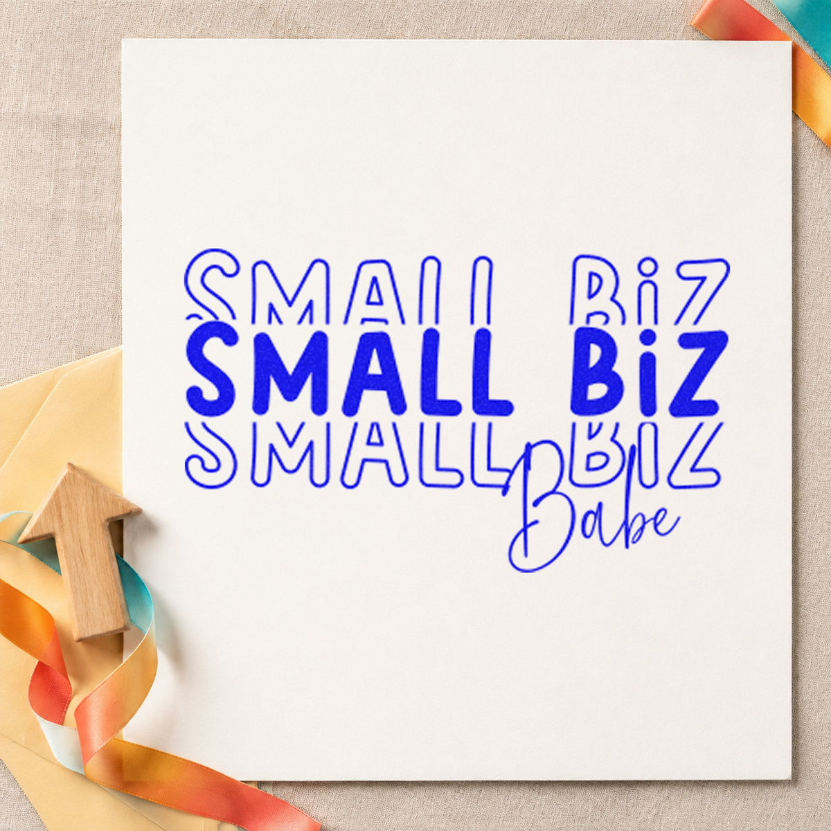 Small Biz Babe Repeated craft stamp in blue ink on cardstock, an easy option for bench cloth printing.
