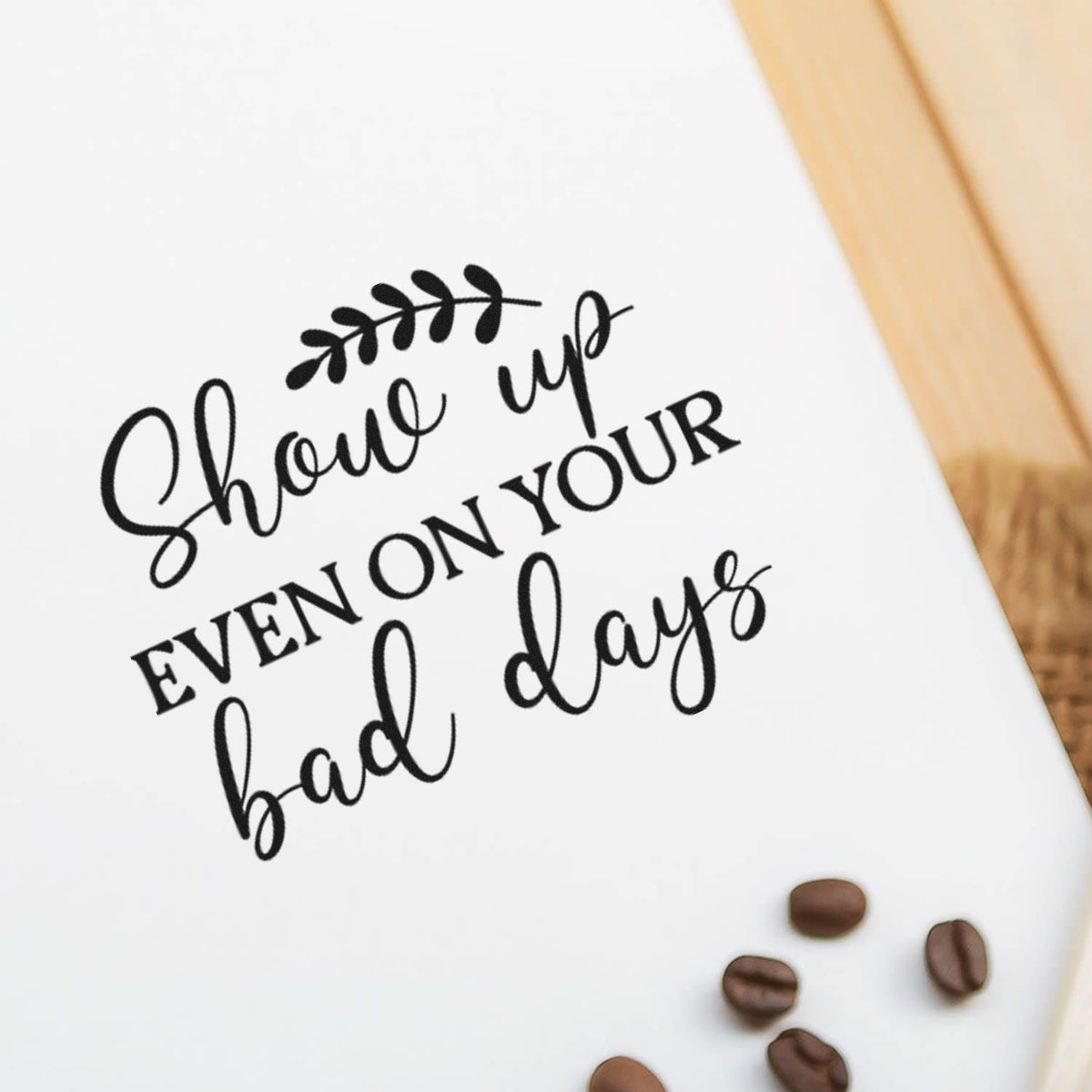 Black custom stamp and seal reading Shove up even on your bad days on white paper, with coffee beans and warm wood accents.