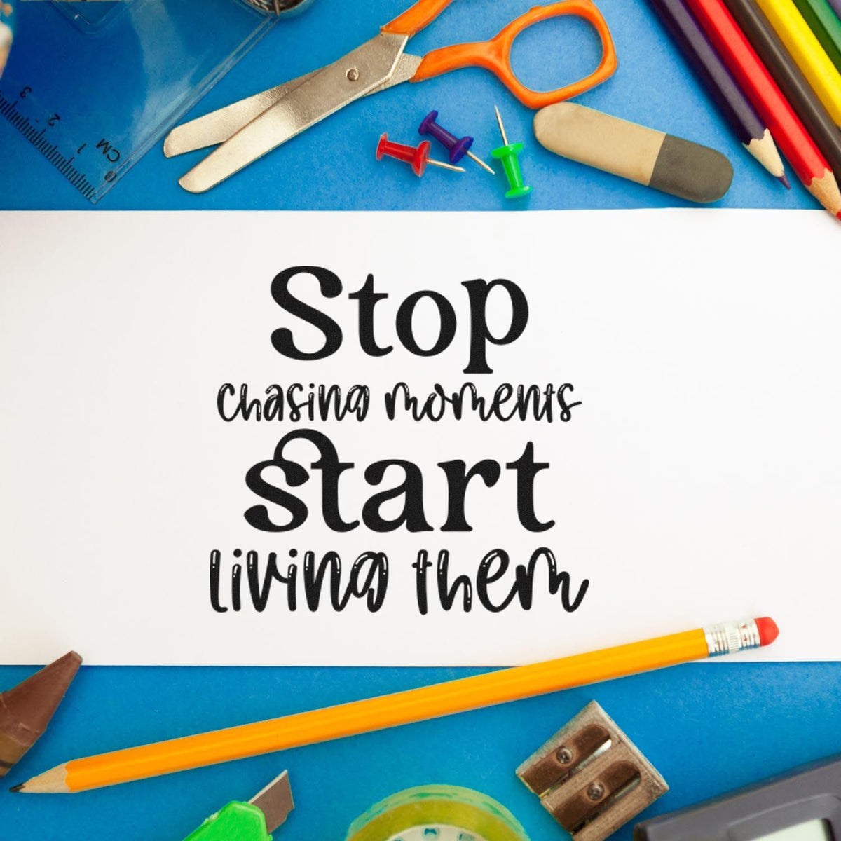 Custom stamp and seal design with black quote on white paper, framed by colorful school supplies on a blue background.