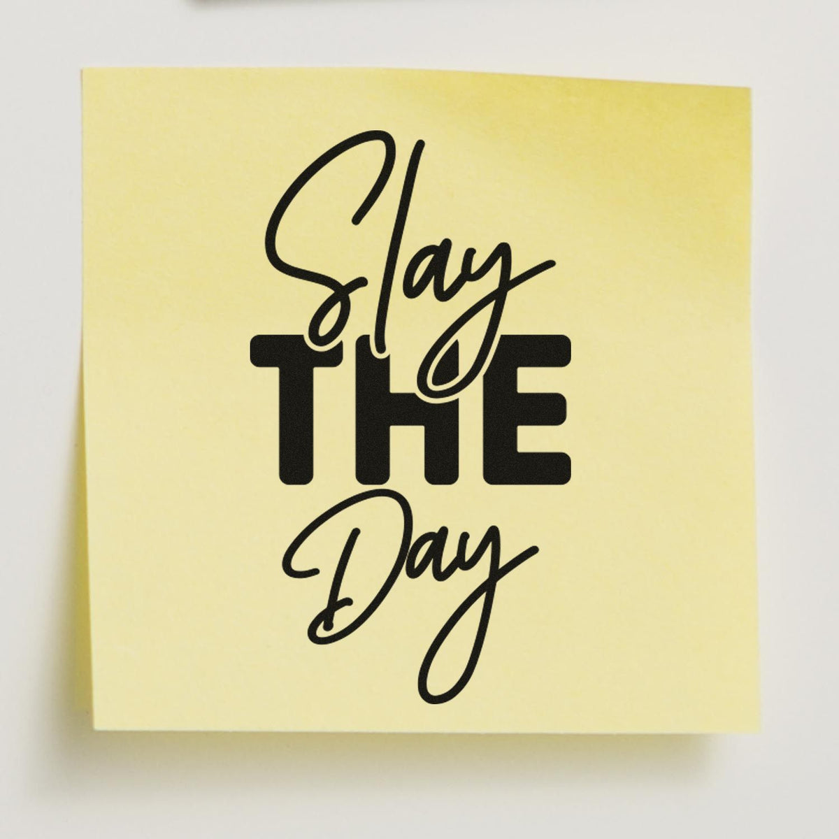 Pale yellow custom stamp seal with black bold and script lettering reading Slay THE Day