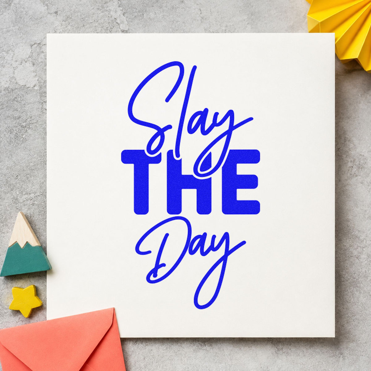 Slay The Day craft stamp imprinted in blue ink on paper, a design suited to framed main hall.