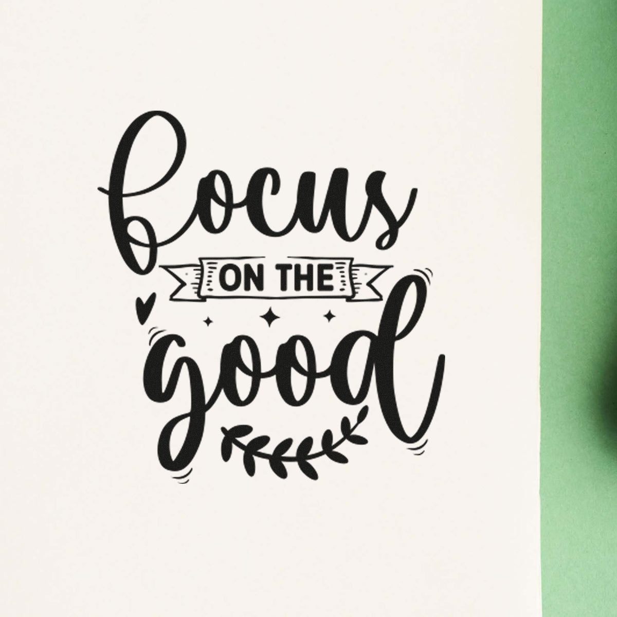 Black rubber stamp seal with focus on the good lettering, heart, stars, and leaf accents on white with green edge.