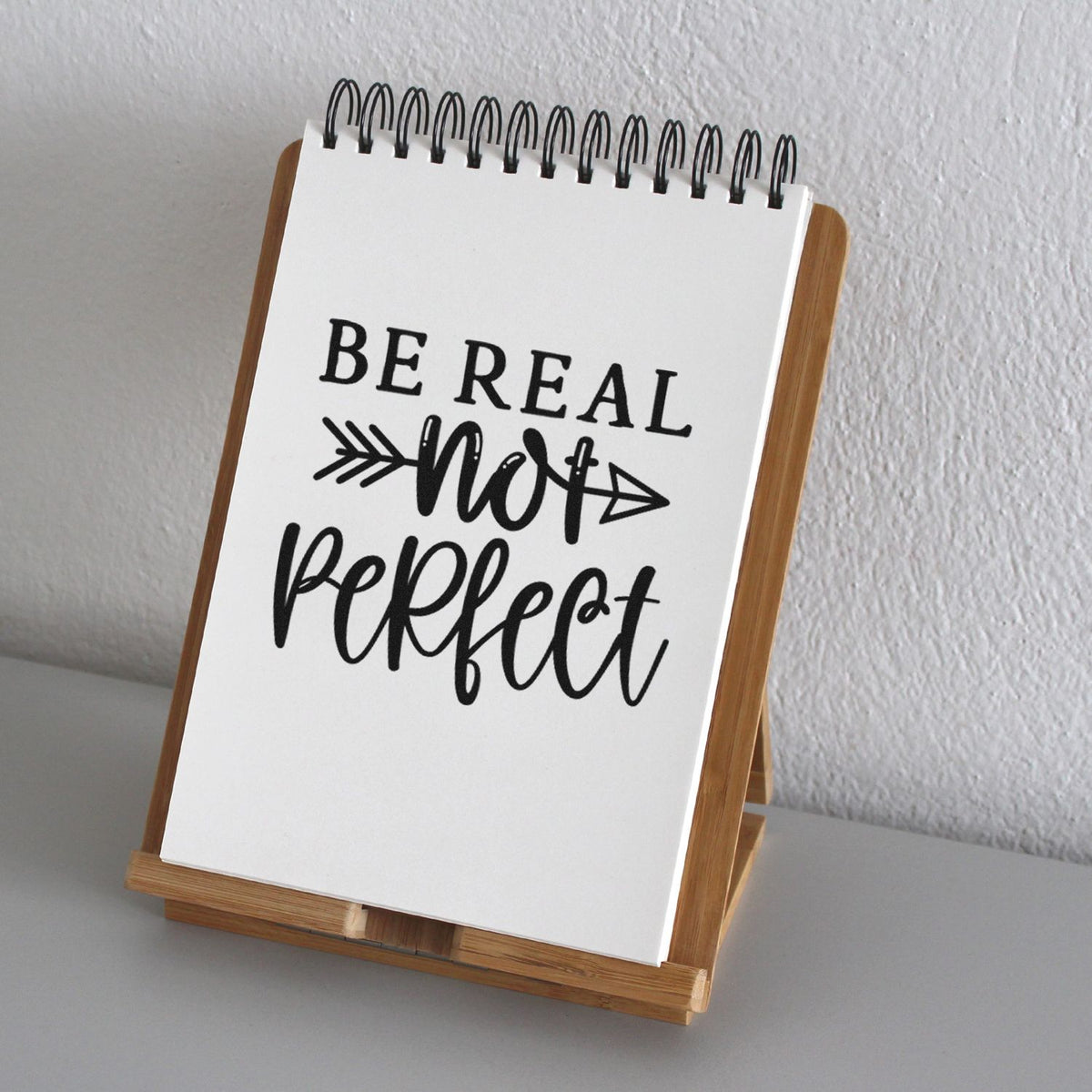 Custom stamp and seal notepad on bamboo stand, white with black Be real not perfect lettering.