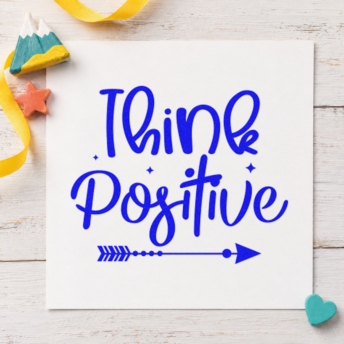 Think Positive Arrow craft stamp imprinted in blue ink on paper, a design suited to framed depot board.