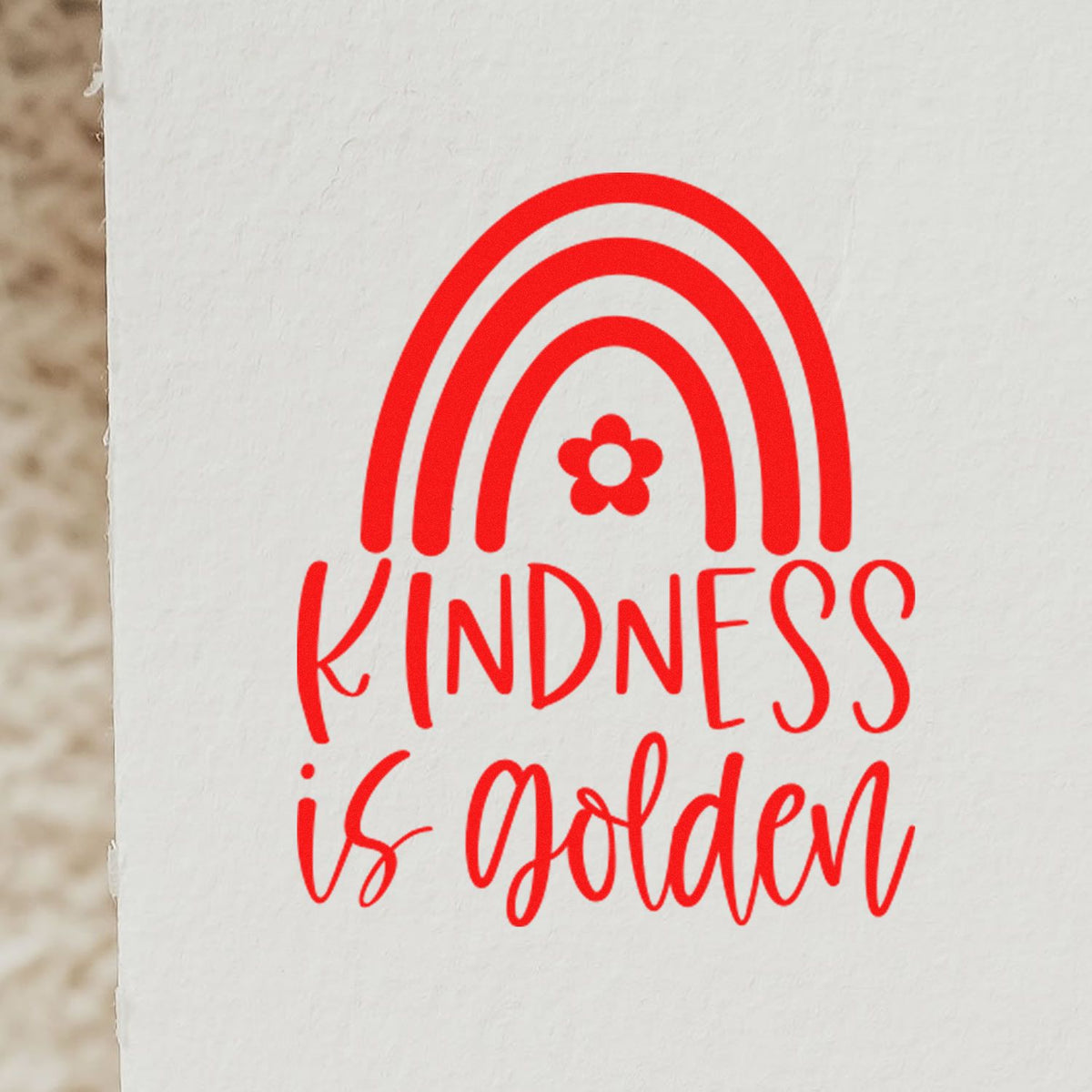 Red kindness is golden stamp seal with red rainbow arch and flower on white paper