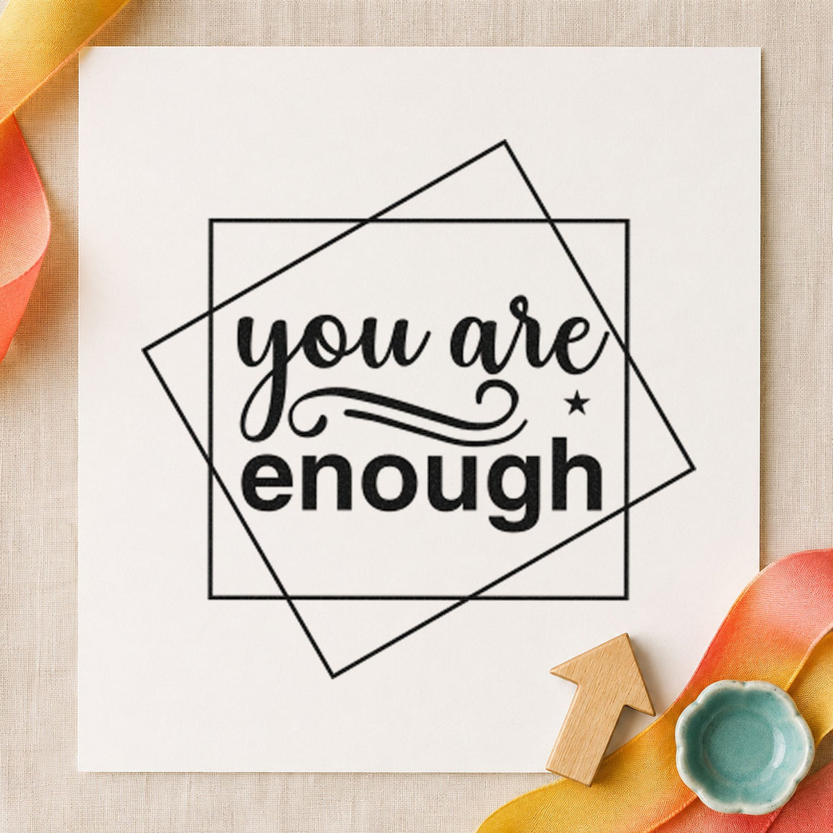 You Are Enough Overlapping Squares craft stamp imprint in black ink on a handmade project, one idea being housewarming tags.
