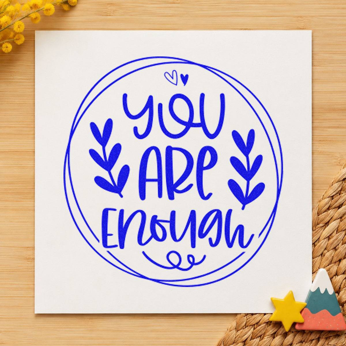 You Are Enough Circle Leaves craft stamp imprinted in blue ink on paper, a design suited to framed dorm wall.