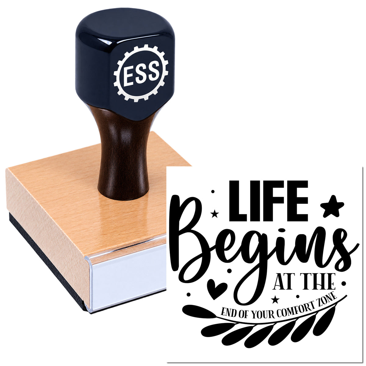 Dark blue ESS rubber stamp on wooden block beside black motivational seal design reading "Life begins at the end of your comfort zone."