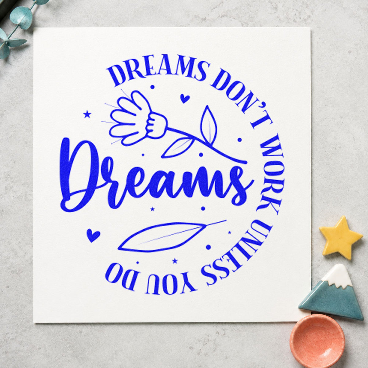 Dreams Don't Work Floral Circle craft stamp in blue ink on cardstock, an easy option for bench cover printing.