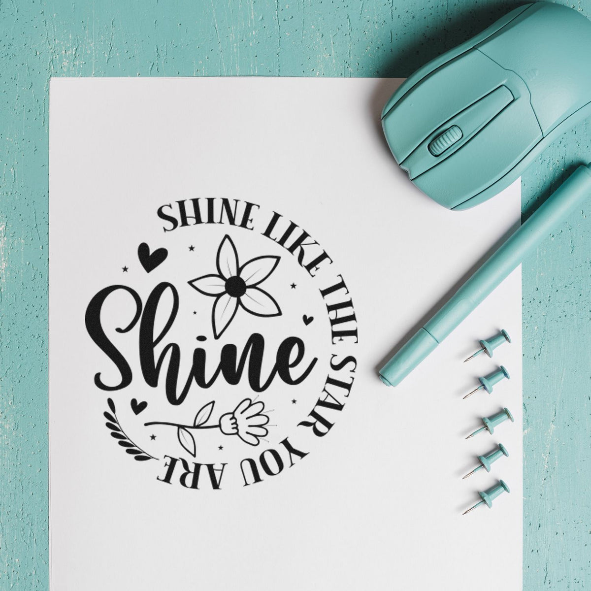 Teal stamp and seal set with black floral Shine logo imprint on white paper.