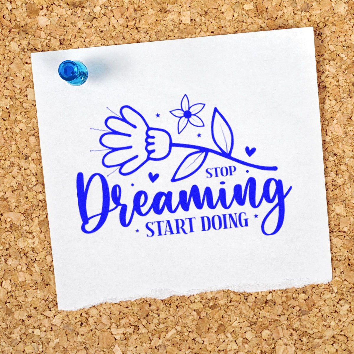 Blue stamp and seal design reading Stop Dreaming Start Doing with flower, hearts, and a blue pushpin on white paper.
