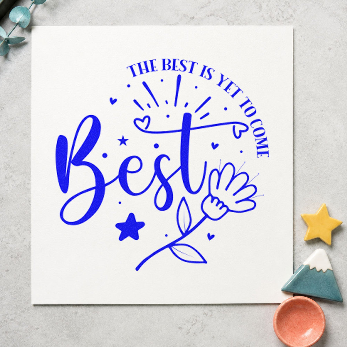 Best Is Yet To Come Floral craft stamp imprinted in blue ink on paper, a design suited to framed guest table.