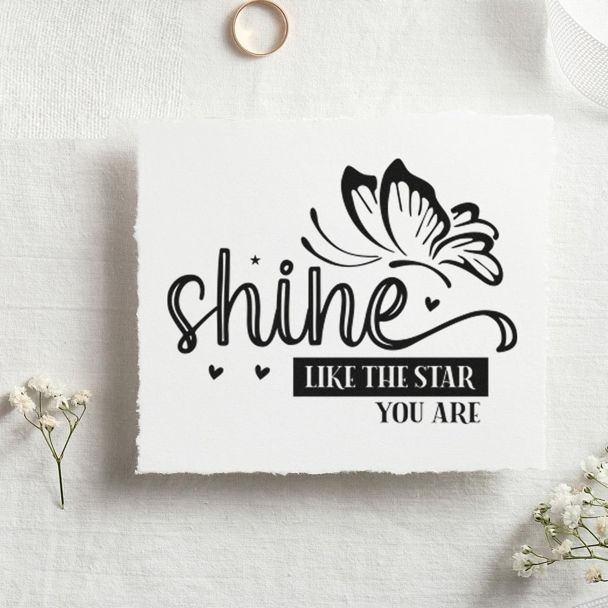 Black butterfly rubber stamp seal with shine like the star you are on white textured paper, accented by tiny hearts.