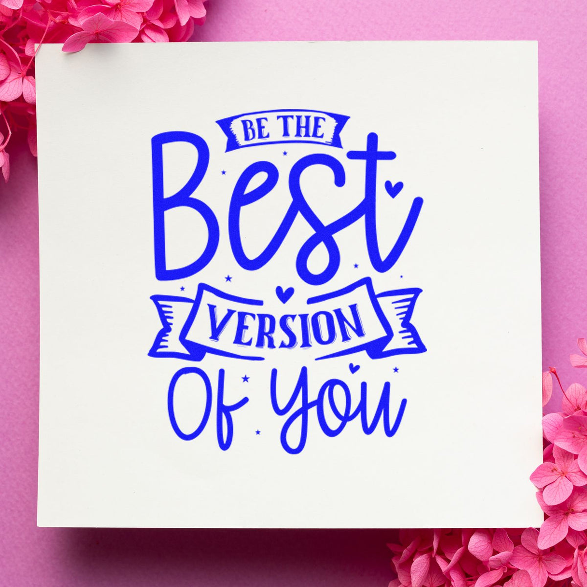 Blue Be the Best Version of You decorative stamp and seal on white card, framed by pink flowers.