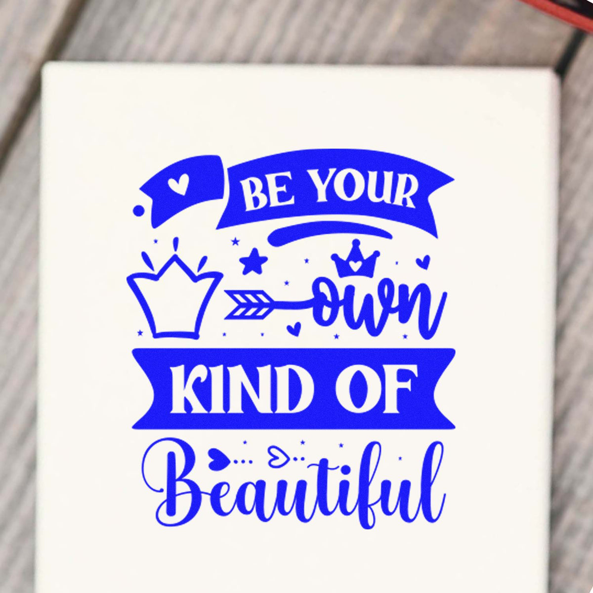 Blue custom stamp seal with crown, hearts and stars, reading Be your own kind of beautiful on white background.