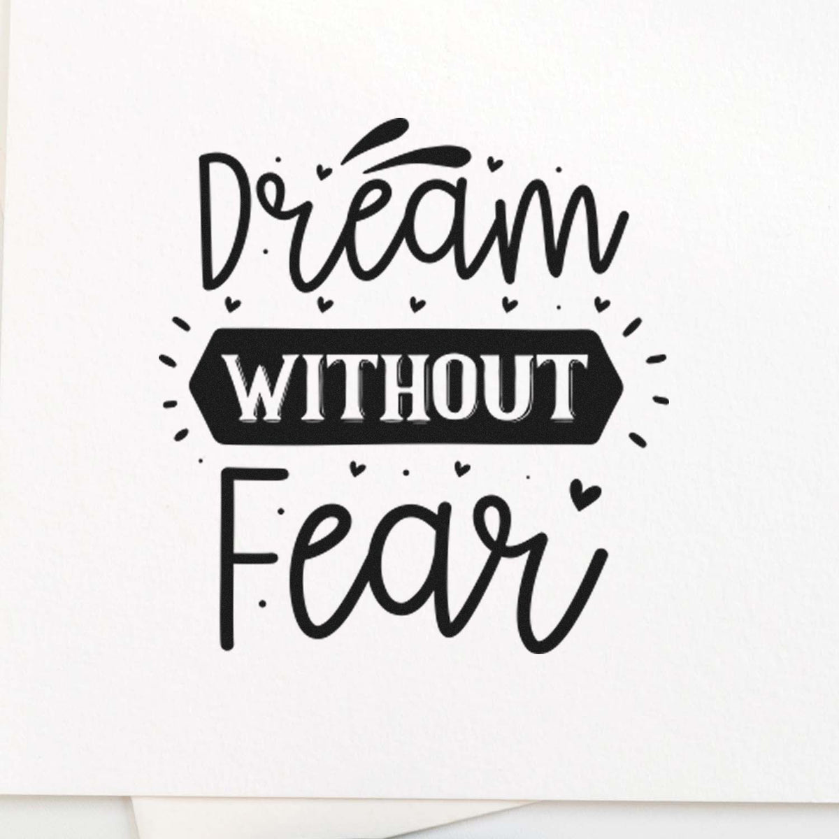 Black stamp and seal design reading Dream without Fear with hearts on a white background.