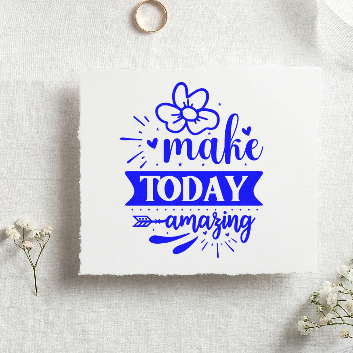 Blue rubber stamp seal reading make TODAY amazing with flower, hearts, and arrow on white paper.