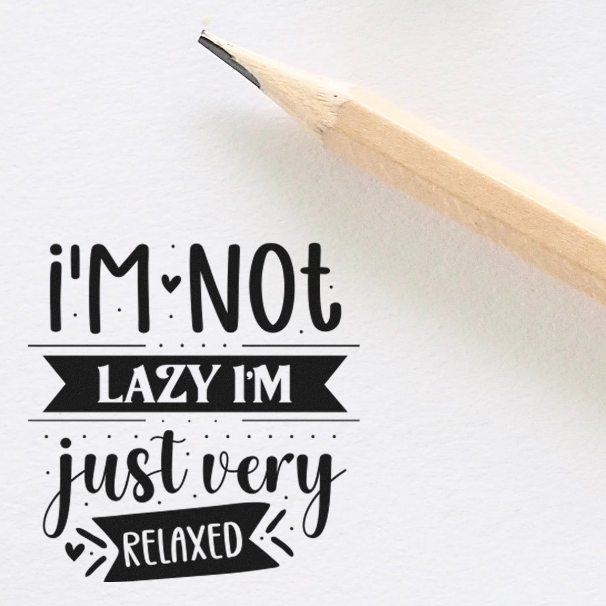 Black rubber stamp design on white paper, with pencil tip, reading Im Not Lazy, Im Just Very Relaxed