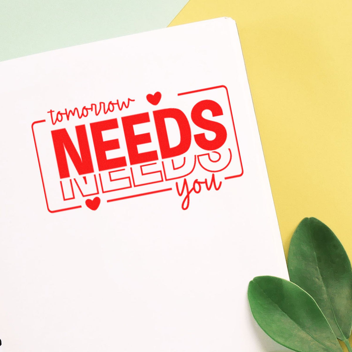 Red motivational stamp and seal design with tomorrow NEEDS you on white paper, yellow background, and green leaves.