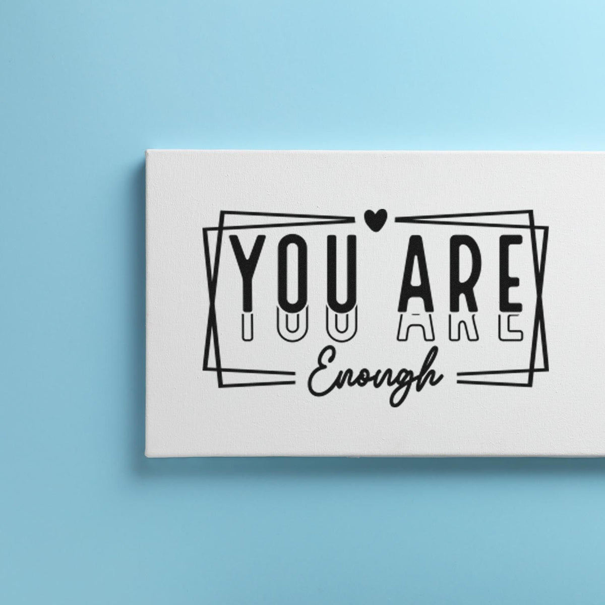 Black You Are Enough rubber stamp with heart and geometric frame on a white seal block, against a light blue background.