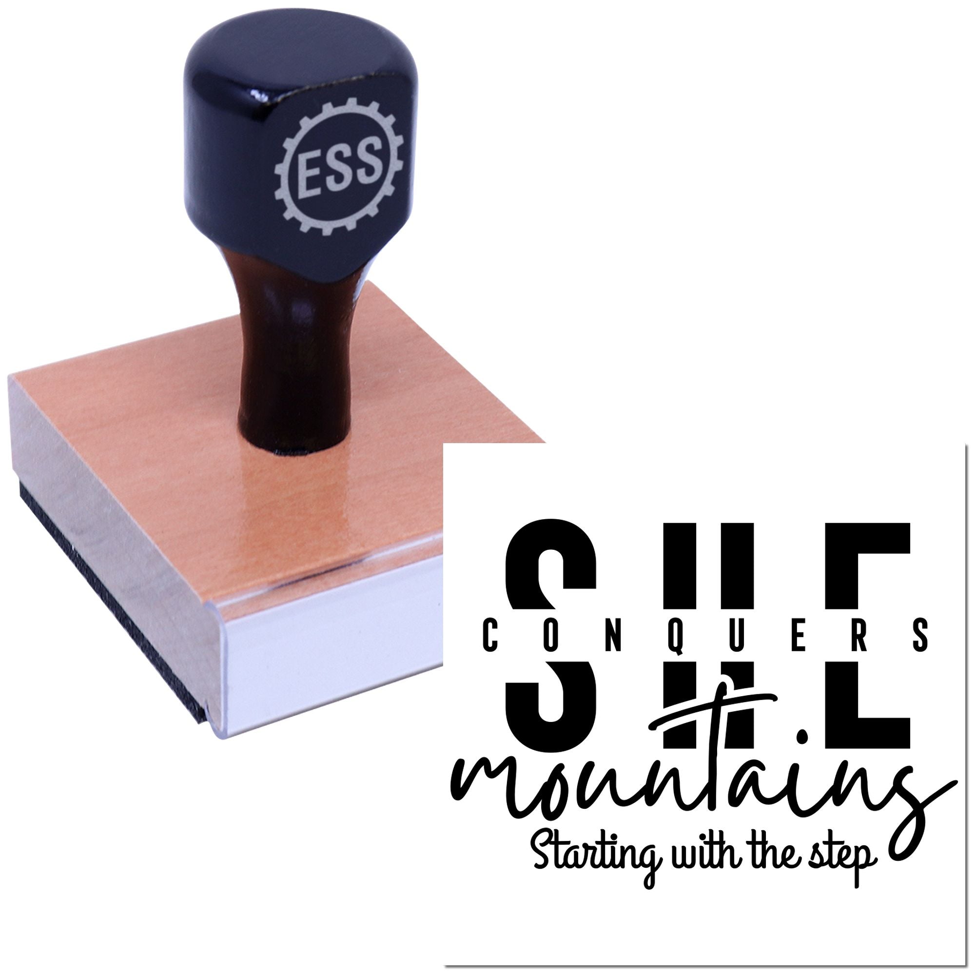 Black ESS rubber stamp with copper-colored seal base and bold Conquers Mountains branding on a white background.