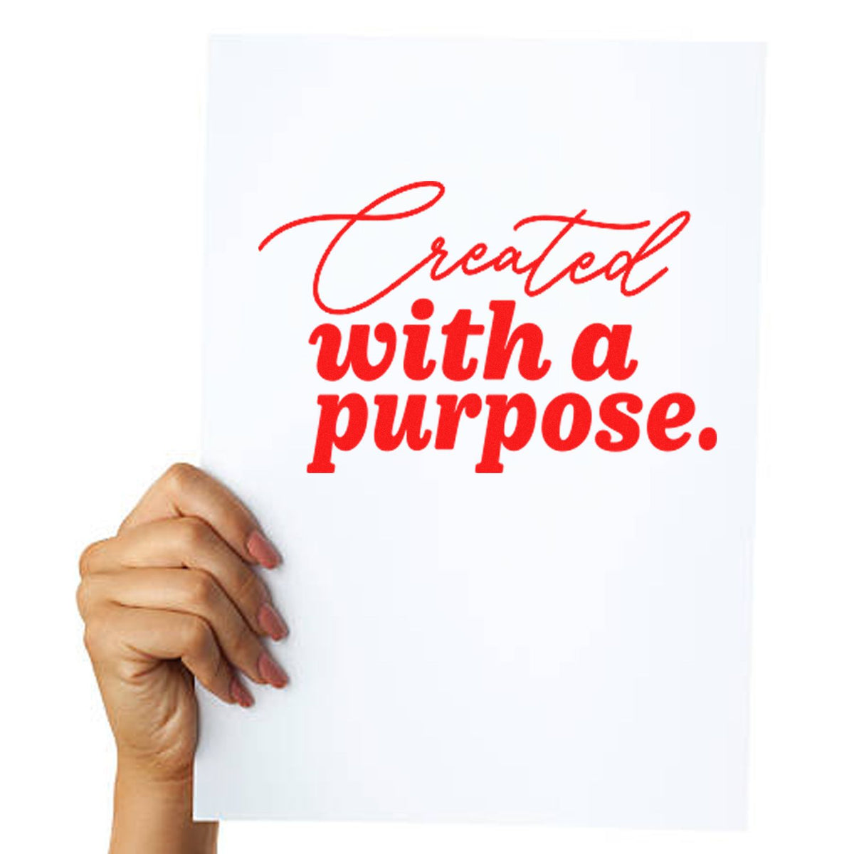 Hand holding white poster with red stamp-style lettering: Created with a purpose.