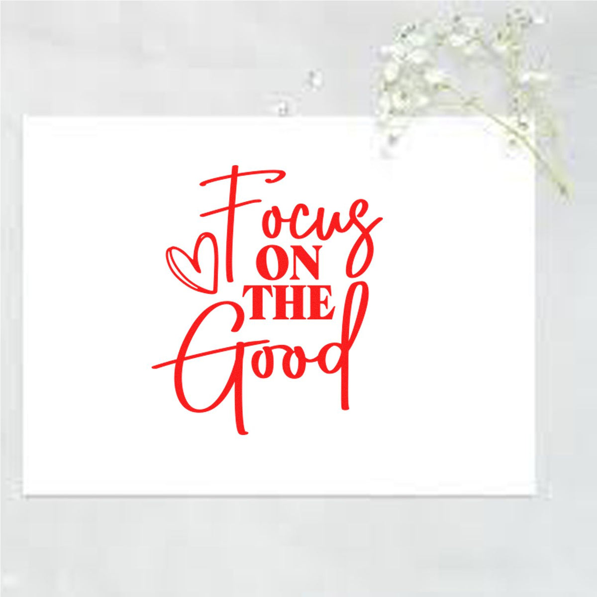 Red calligraphy stamp seal reading Focus on the Good with heart on white square card.