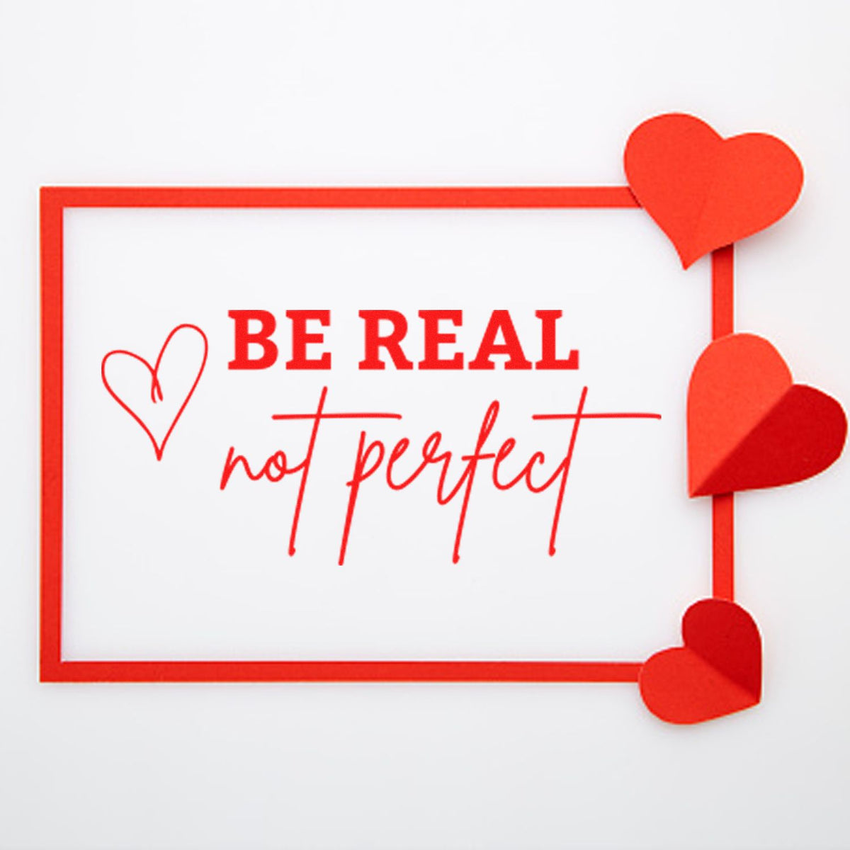 Red stamp and seal product with Be real, not perfect text, heart accents, and border on a white background.