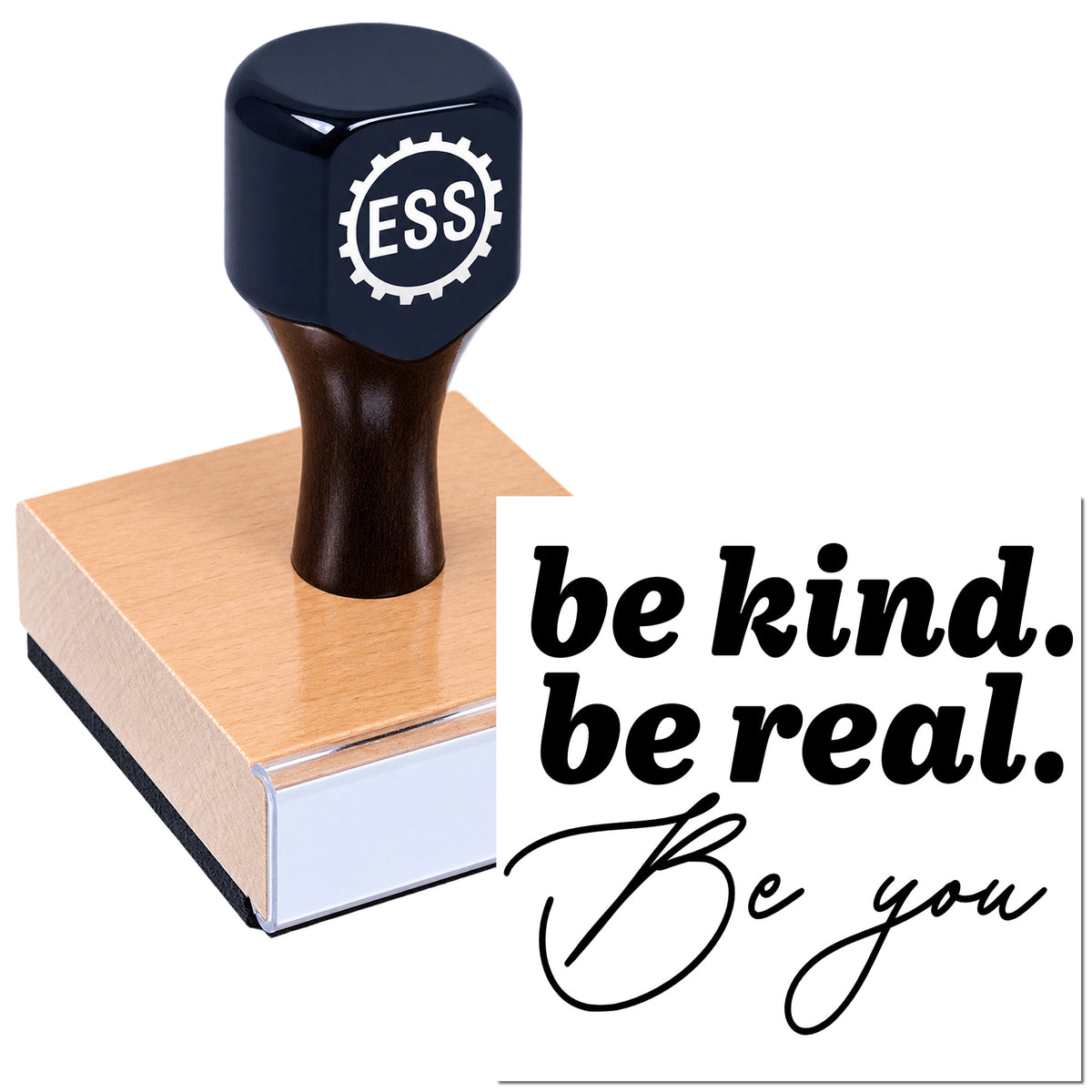 Black ESS rubber stamp on a pink seal pad beside a white card reading "be kind. be real. Be you."