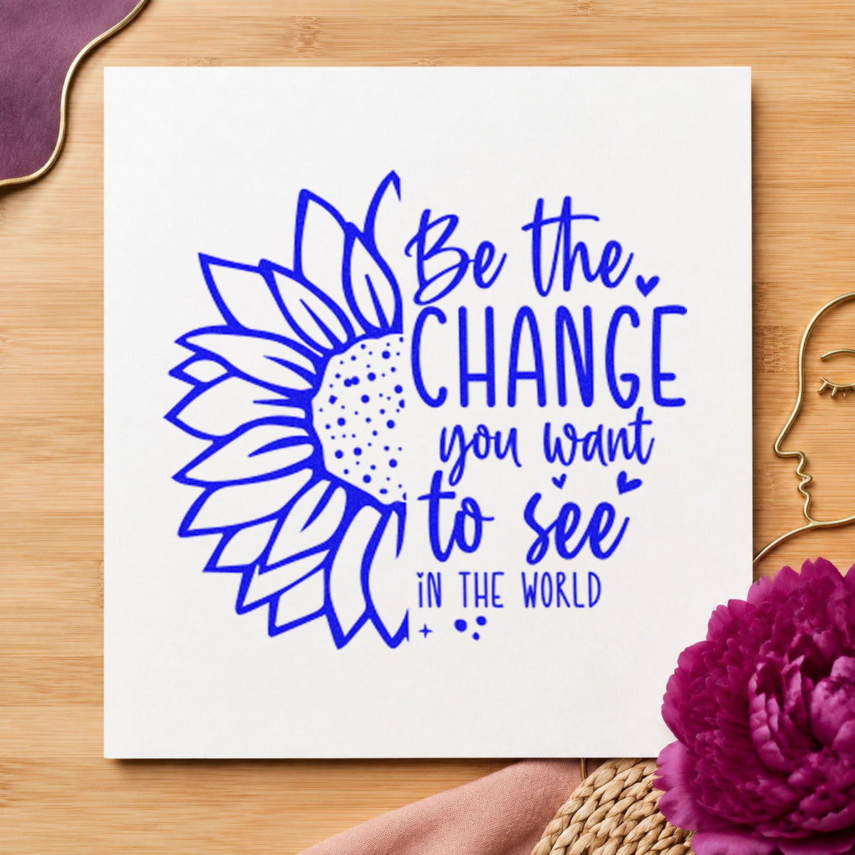 Be The Change Sunflower craft stamp imprinted in blue ink on paper, a design suited to framed school office.