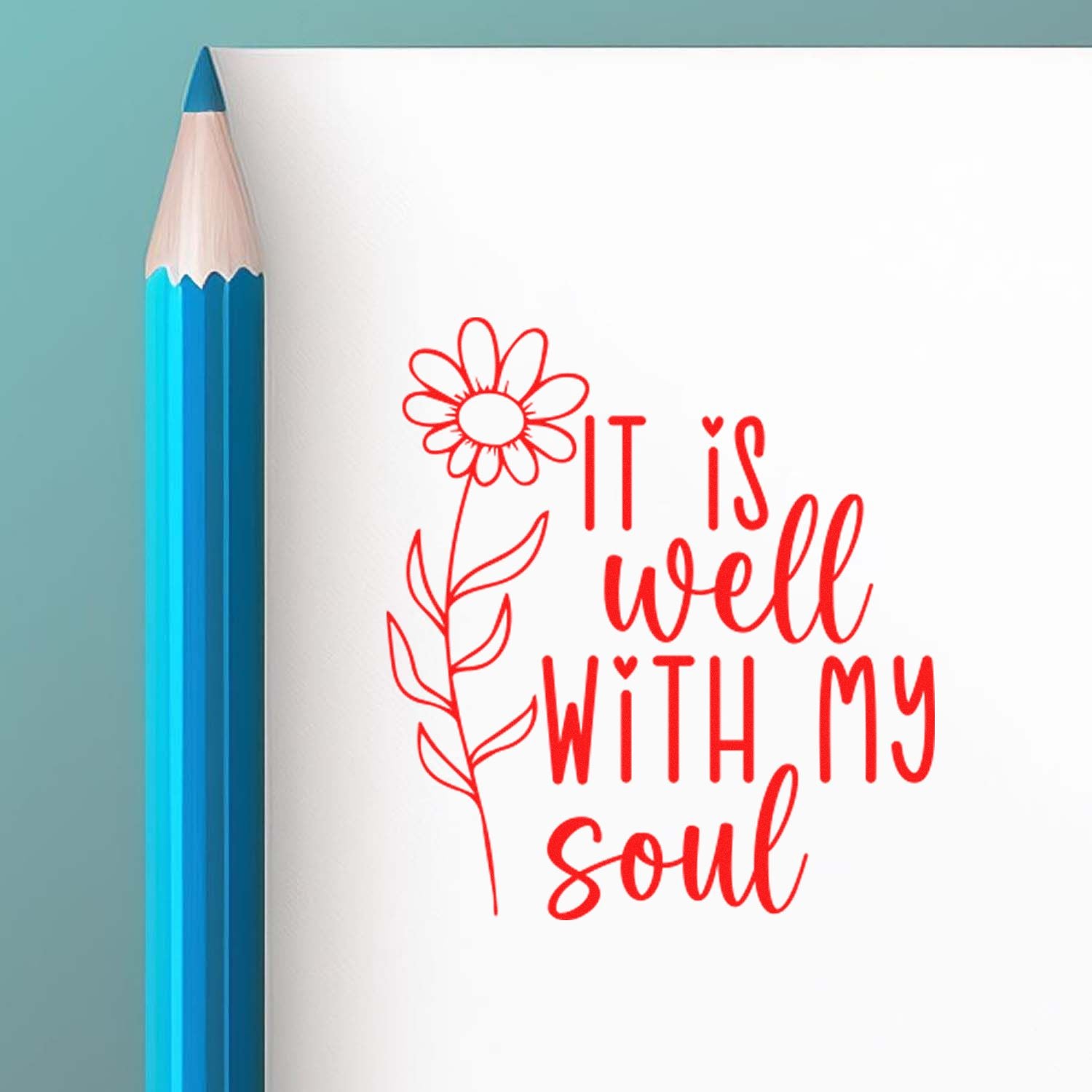 Red floral stamp/seal reading It is well with my soul beside a blue pencil on white paper.