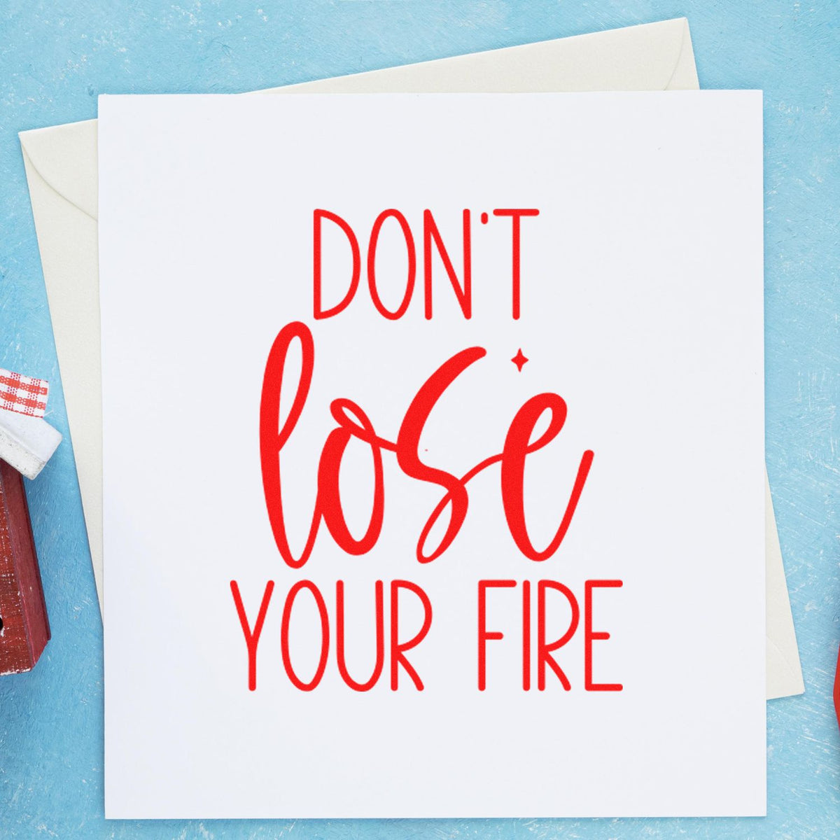 Red stamp and seal reading DONT lose your FIRE on white card, with envelopes on a light blue background.