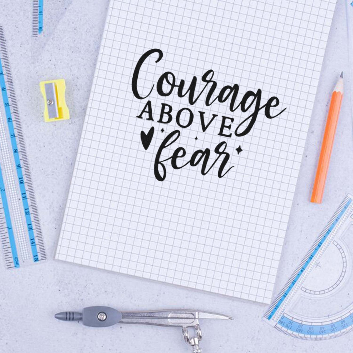 Courage Above Fear Wood Handle Stamp imprint stamped in black ink. Courage ABOVE fear appears in mixed lettering with a heart and sparkles.