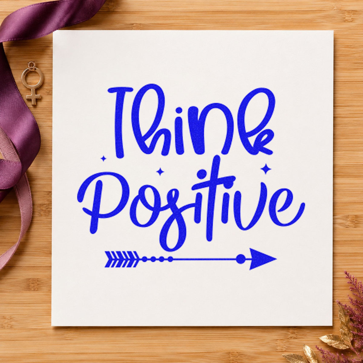Think Positive Arrow Script craft stamp imprinted in blue ink on paper, a design suited to framed lane wall.