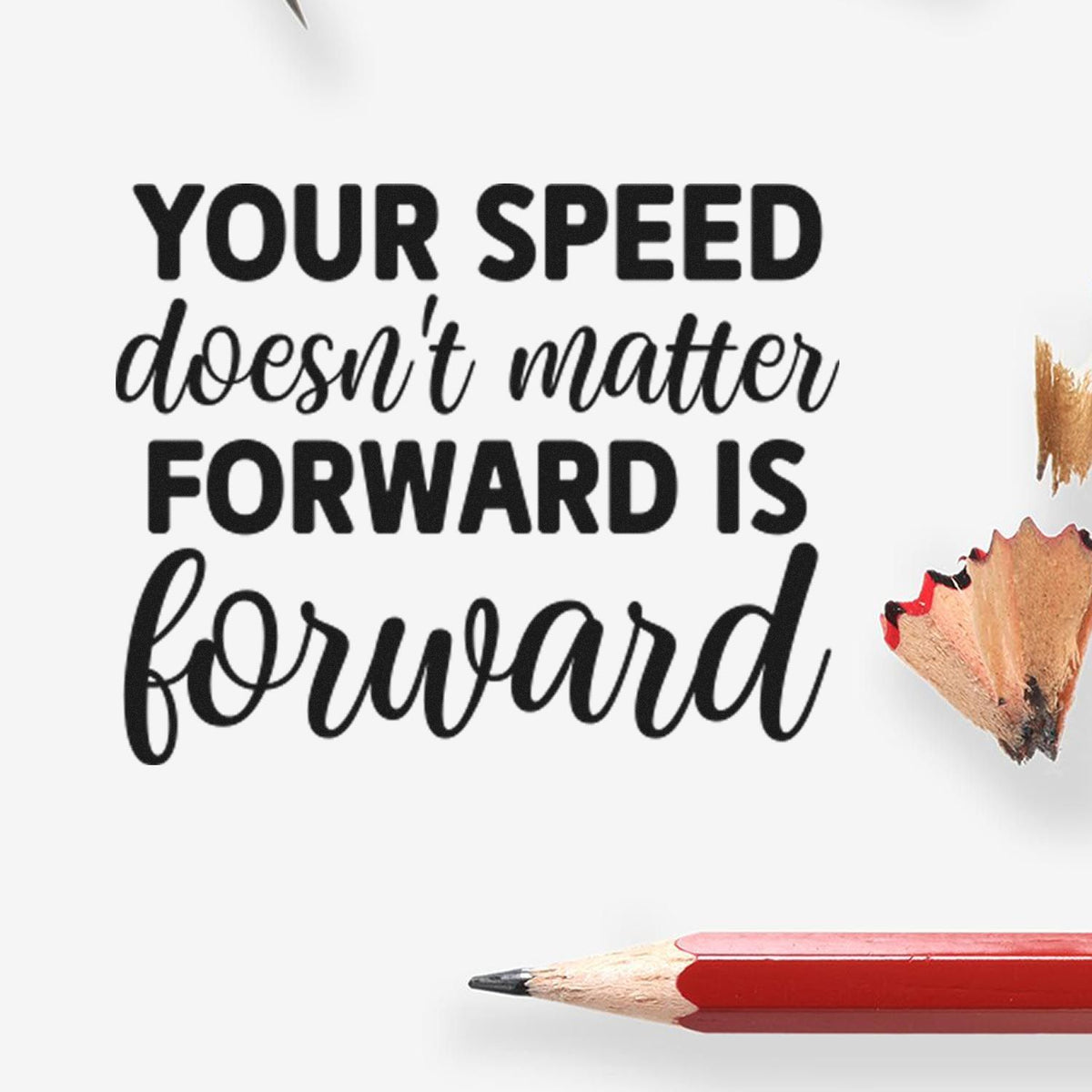 Black rubber stamp quote on white: Your speed doesnt matter, forward is forward, with red pencil and shavings.