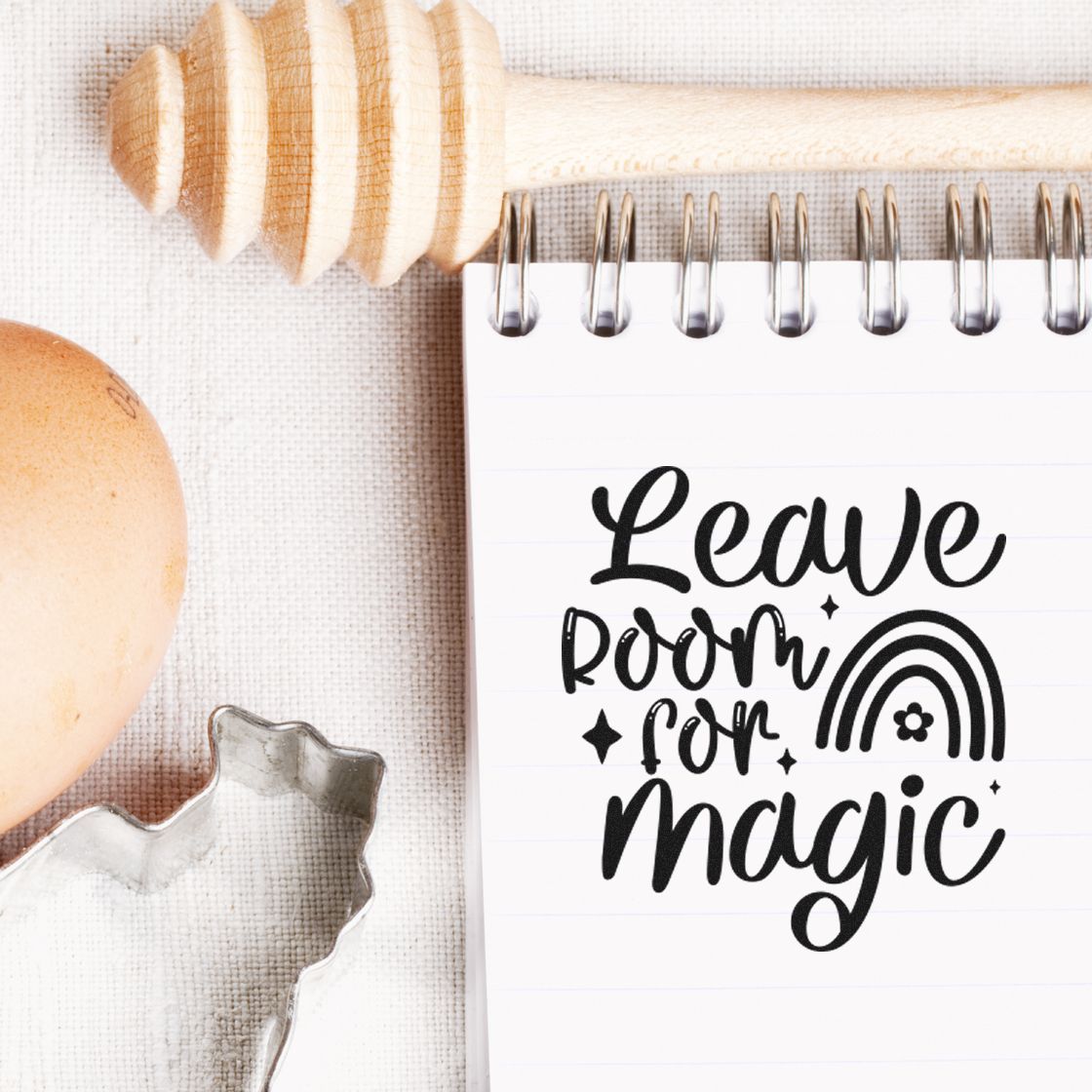 Black Leave room for magic stamp and seal on a white spiral notebook with rainbow, beside wooden tool and clear cutter.