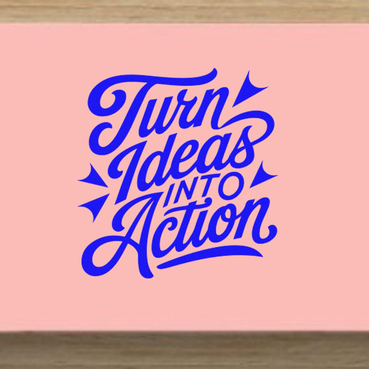 Blue Turn Ideas Into Action script stamp seal on a pink background with bold decorative starbursts.