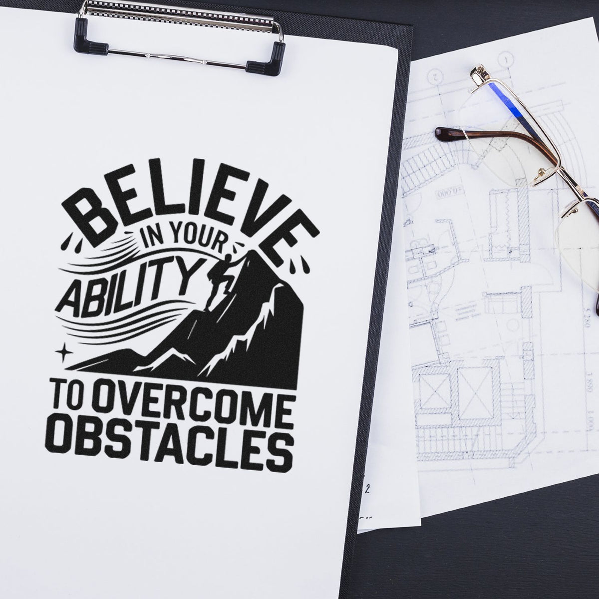 Black custom stamp and seal design on white clipboard: Believe in your ability to overcome obstacles with mountain graphic.