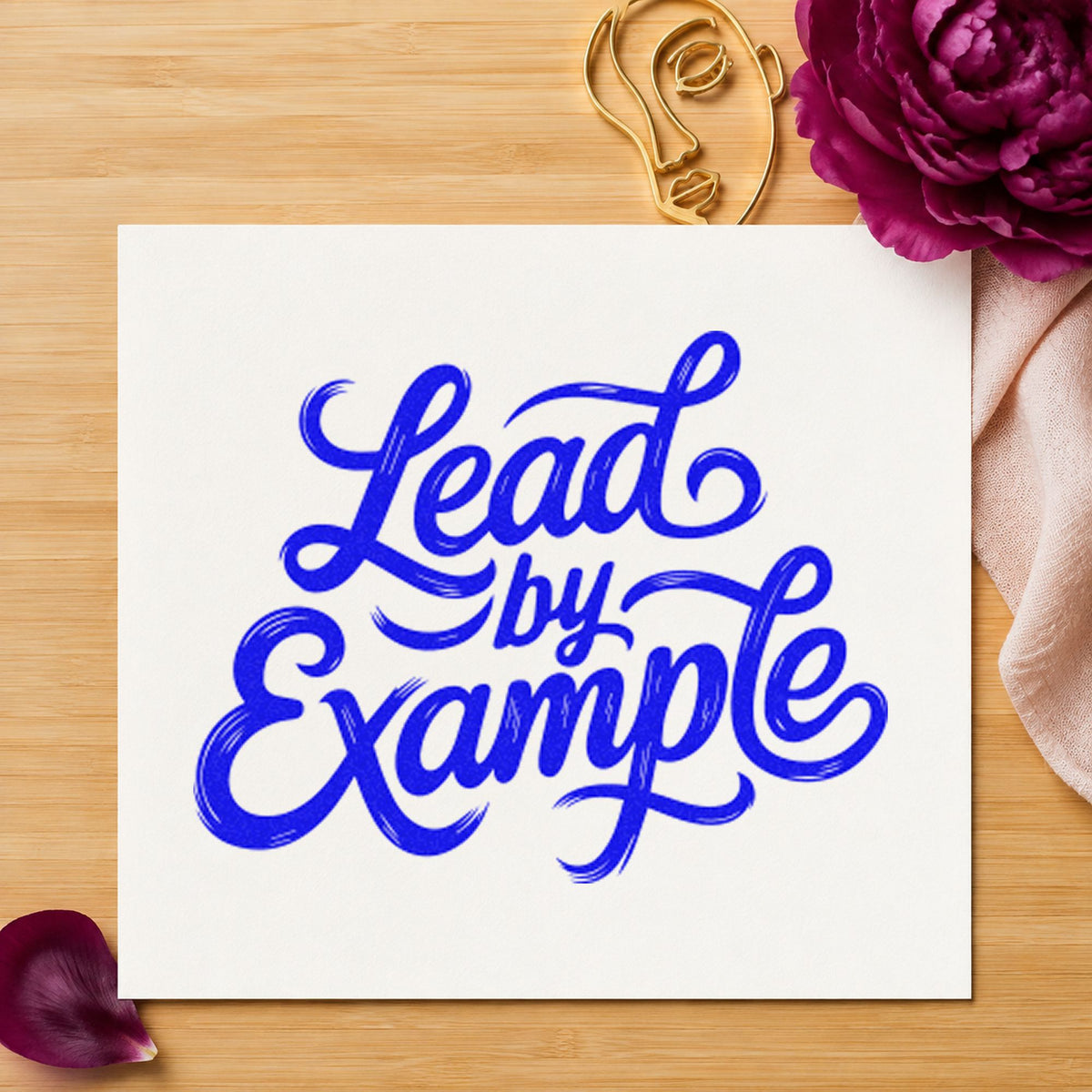 Lead By Example Script craft stamp imprinted in blue ink on paper, a design suited to framed truck bay.